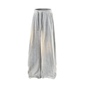 Plus size black straight-leg trousers with hollow-out design and elastic waistband laid flat.