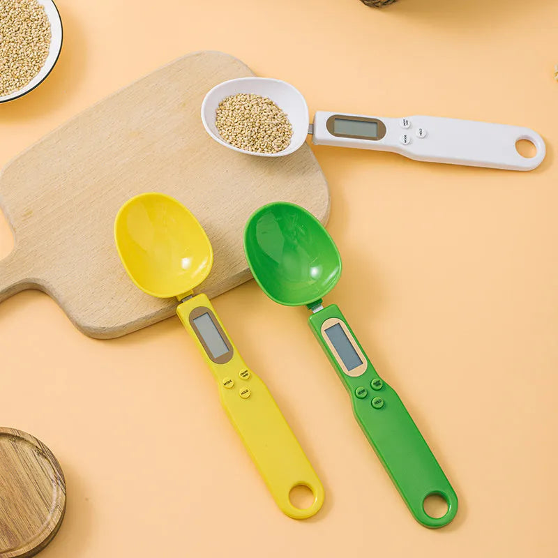 White electronic digital spoon scale with LCD display on a kitchen counter.