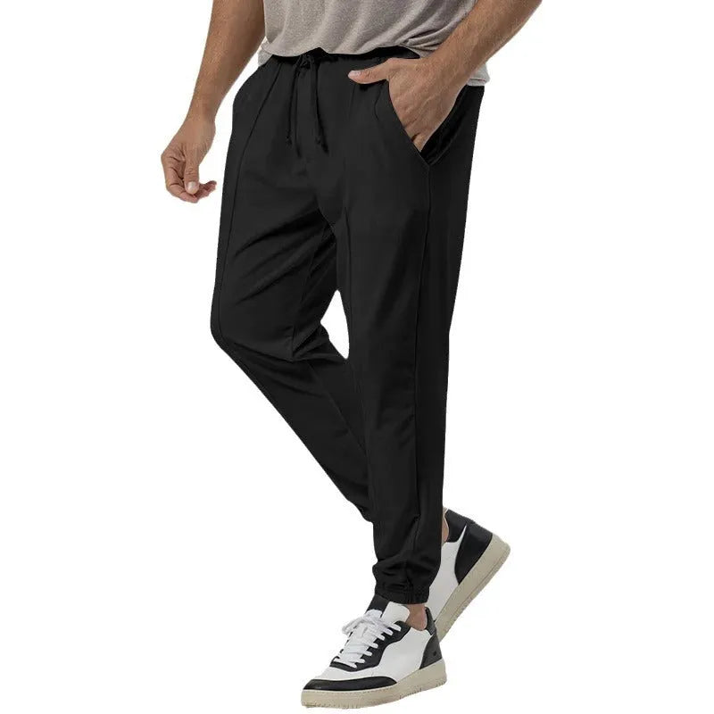 Men's grey cotton blend casual track sweatpants with a tapered leg on a plain background.