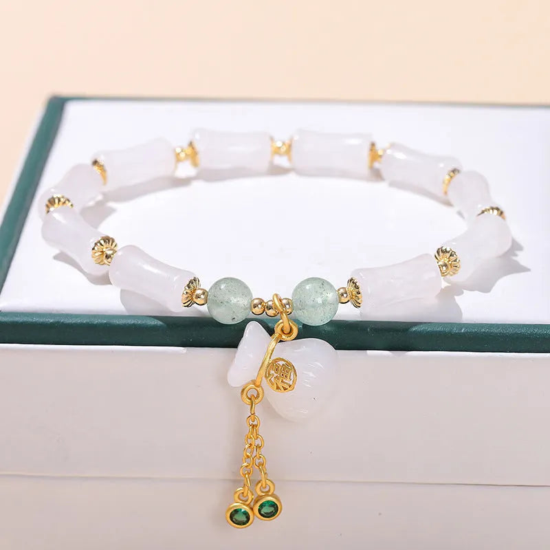 Green crystal bracelet with adjustable string closure on wrist