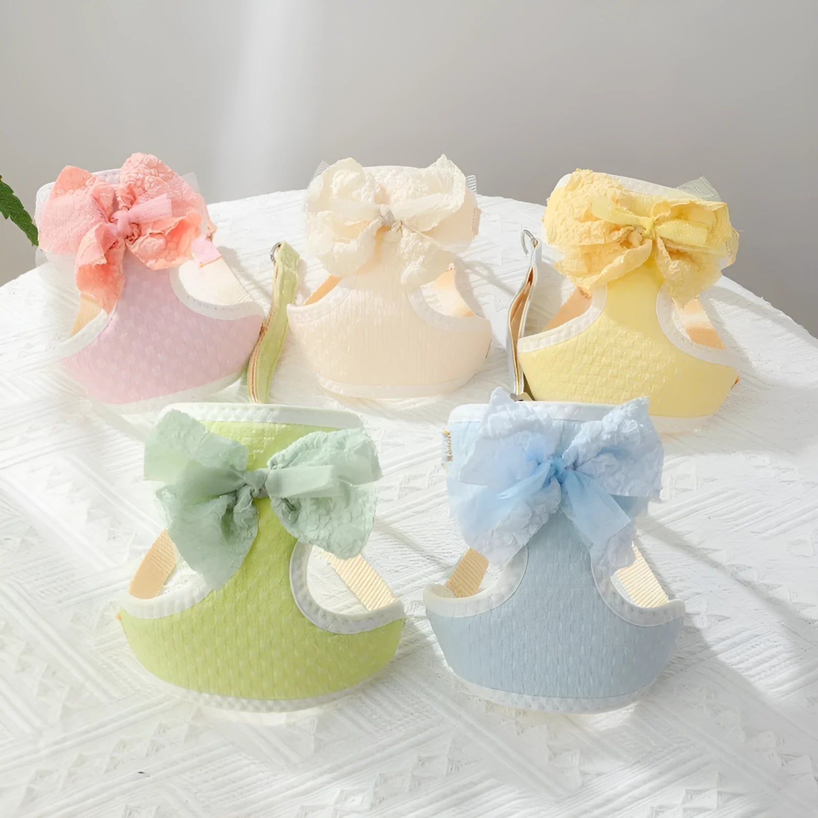 Hand holding rope chest strap for small puppies in beige cloth on a light background
