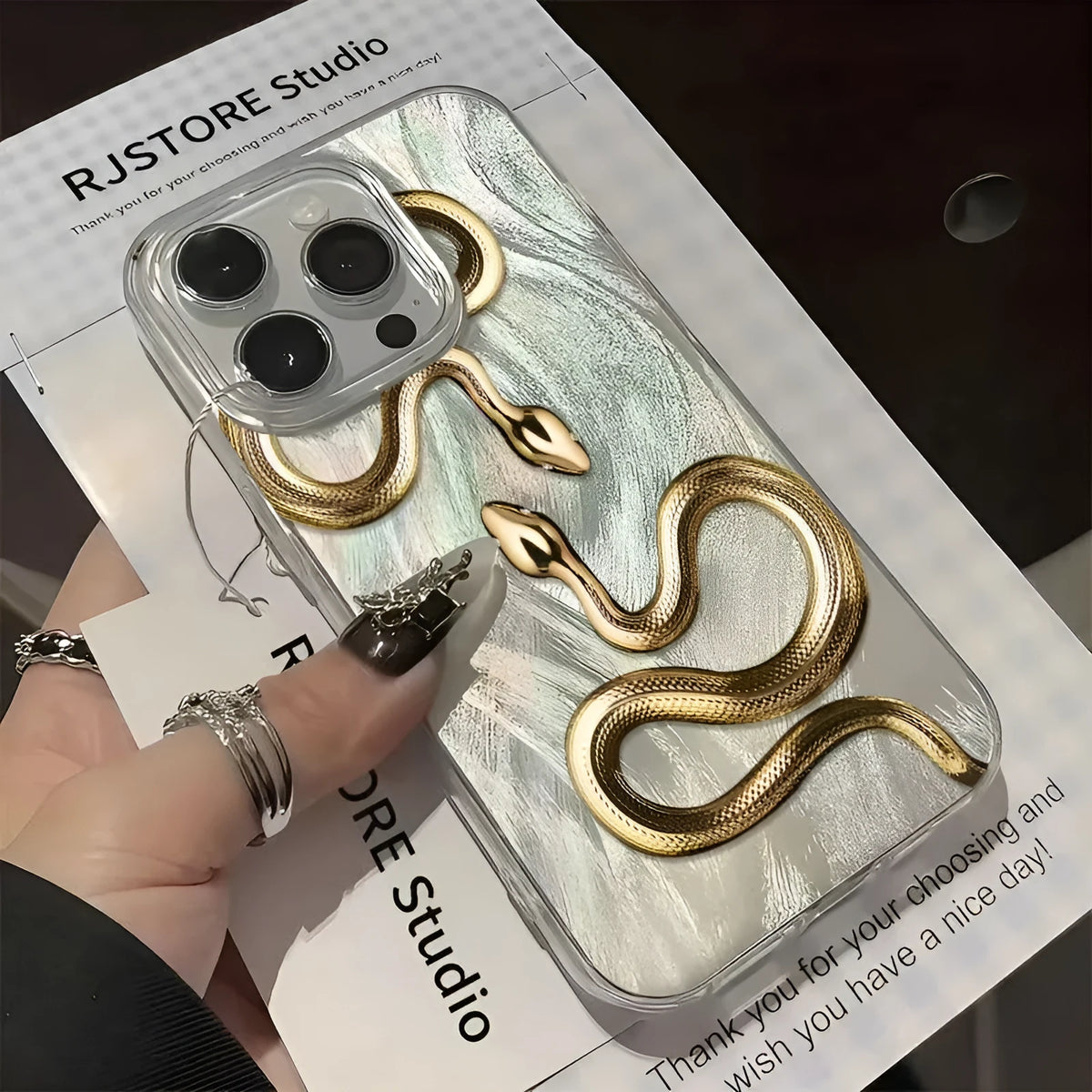 Gold snake design hard PC phone case for iPhone 16 Plus with white base and cartoon style