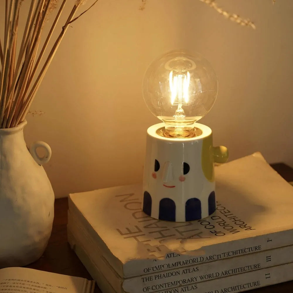 Handmade ceramic bedside lamp with ball headlight colour finish on a table.