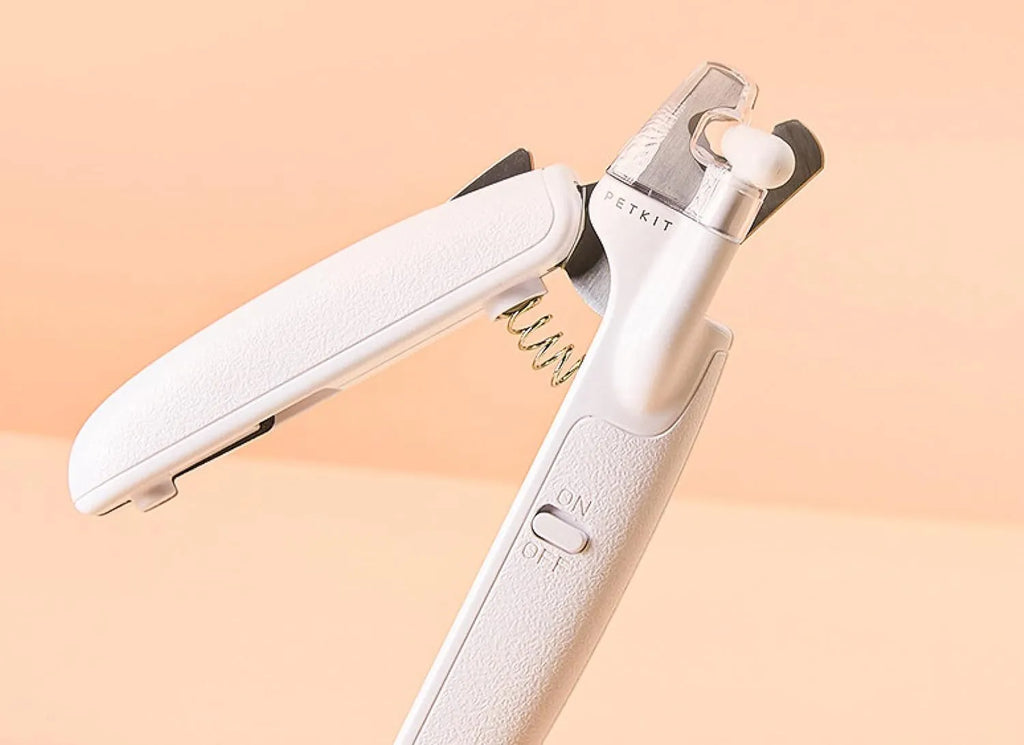 White pet nail clippers with LED light, transparent guard, and built-in file for cats and dogs.