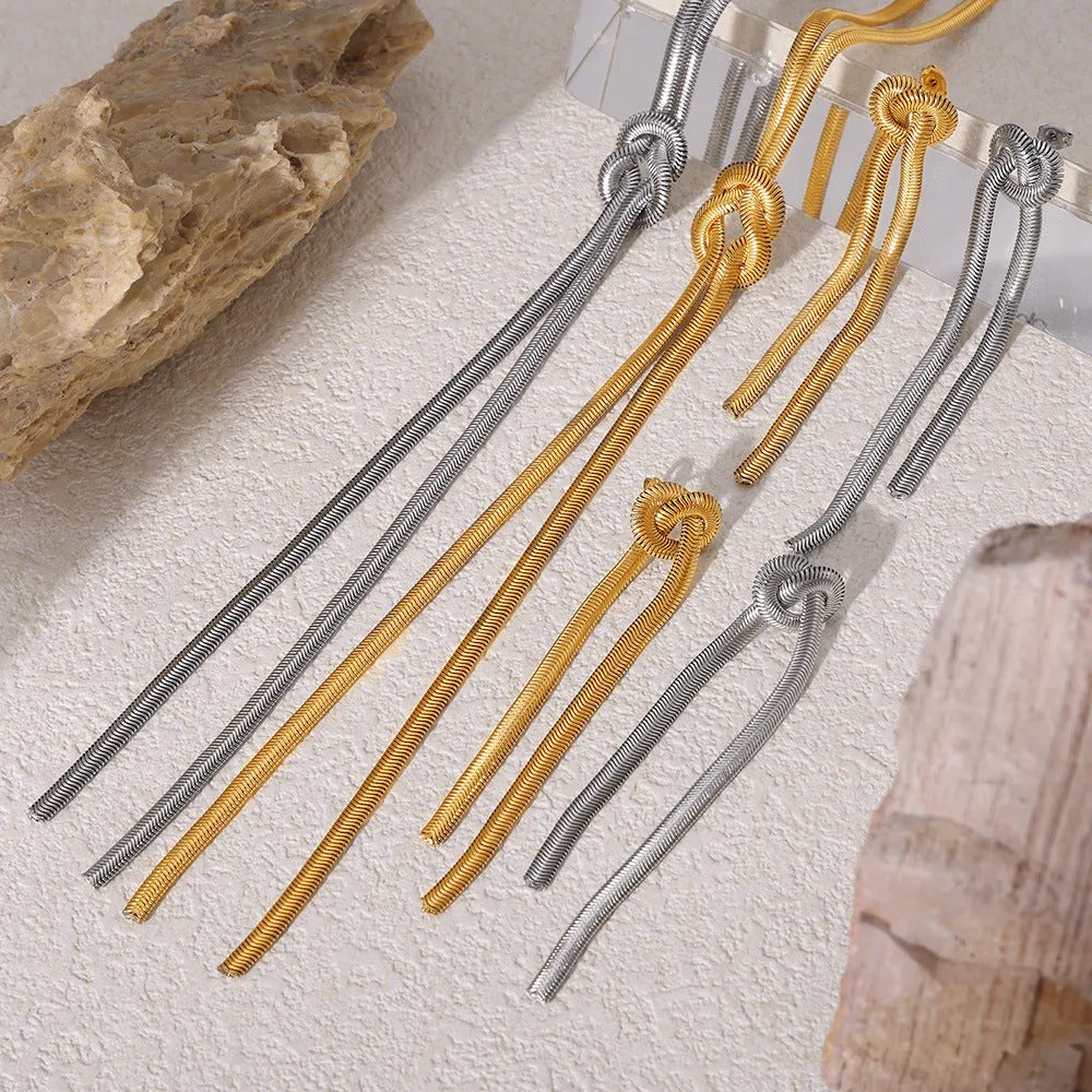 Gold plated titanium steel necklace with snake chain and knotted tassel pendant, shown with matching earrings.