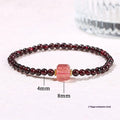 Geometric square garnet bracelet with carved Pixiu and strawberry quartz accents on a purple sand background.