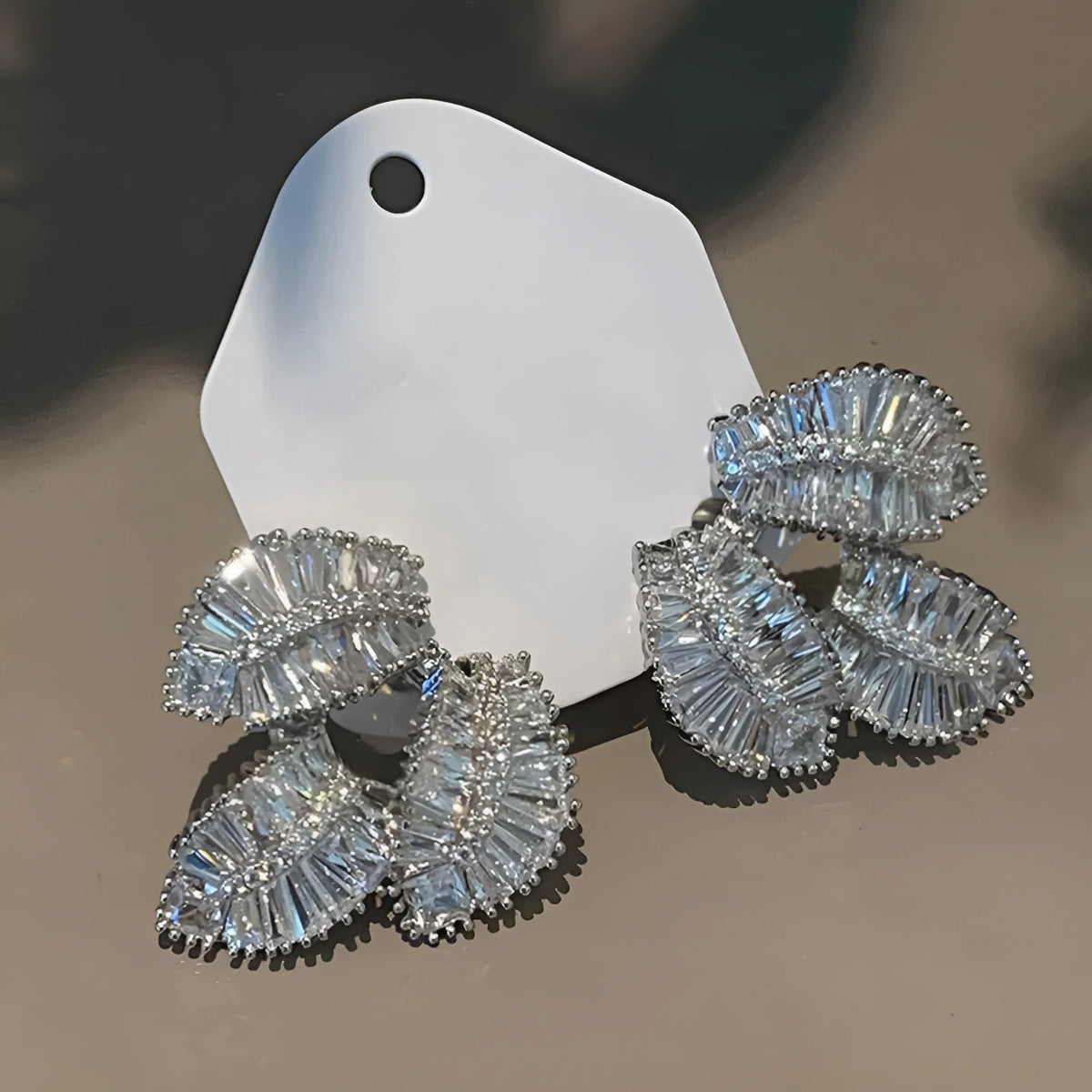 Leaf shaped zircon earrings in white gold colour with copper base and quadrilateral inlay