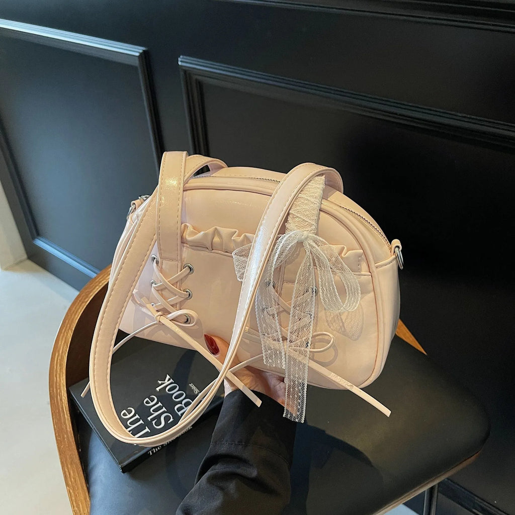Women's PU leather handbag with bandage bow detail showing internal mobile phone pocket