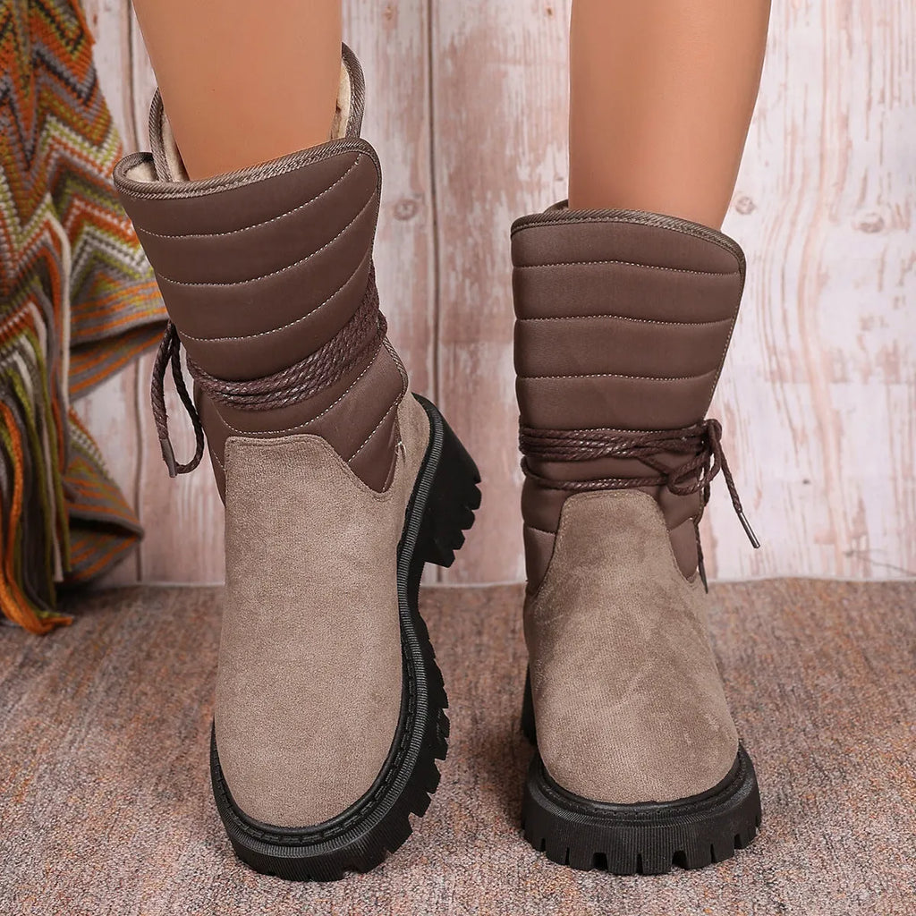 Black women's high-top suede snow boots with chunky rubber sole and lace-up design