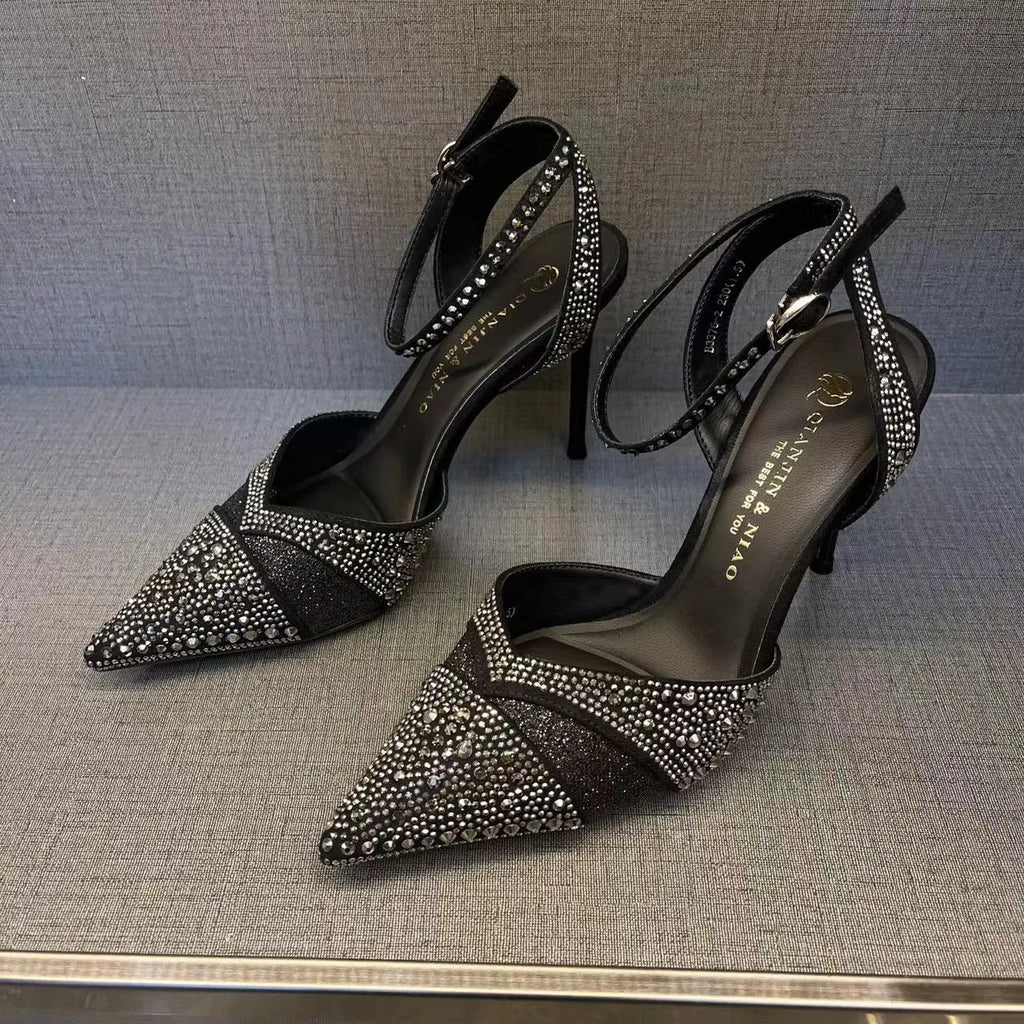Women's black pointed toe stiletto heels with a hollow design and red sole.