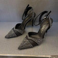 Women's black pointed toe stiletto heels with a hollow design and red sole.