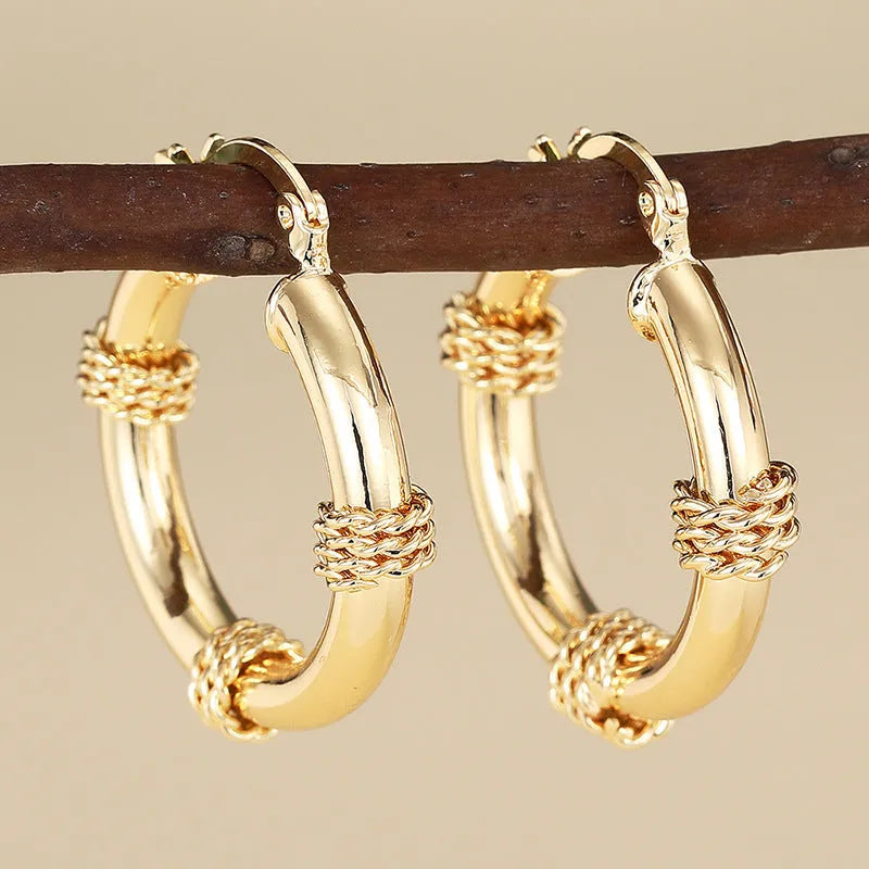 Geometric women's earrings made of copper in a gold finish, featuring a ring and line design.