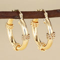 Geometric women's earrings made of copper in a gold finish, featuring a ring and line design.