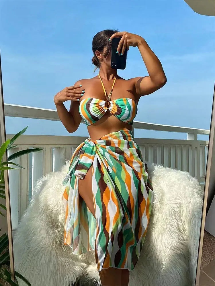 Women's yellow green three-piece swimsuit set with bikini top, briefs, and a printed beach skirt.