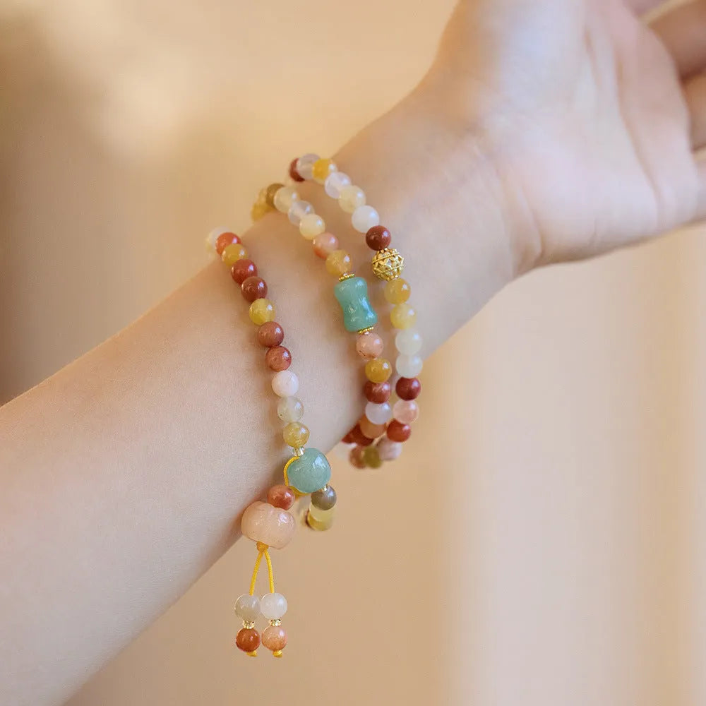Women's Jinsi Jade bracelet with three-circle pumpkin design and tassels on a wrist