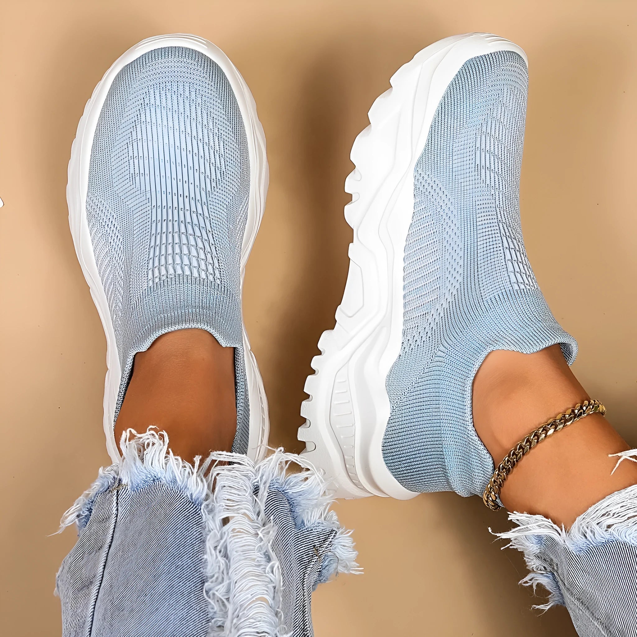 Light blue women's mesh slip-on sports shoes with a round toe and mid heel on a white background.