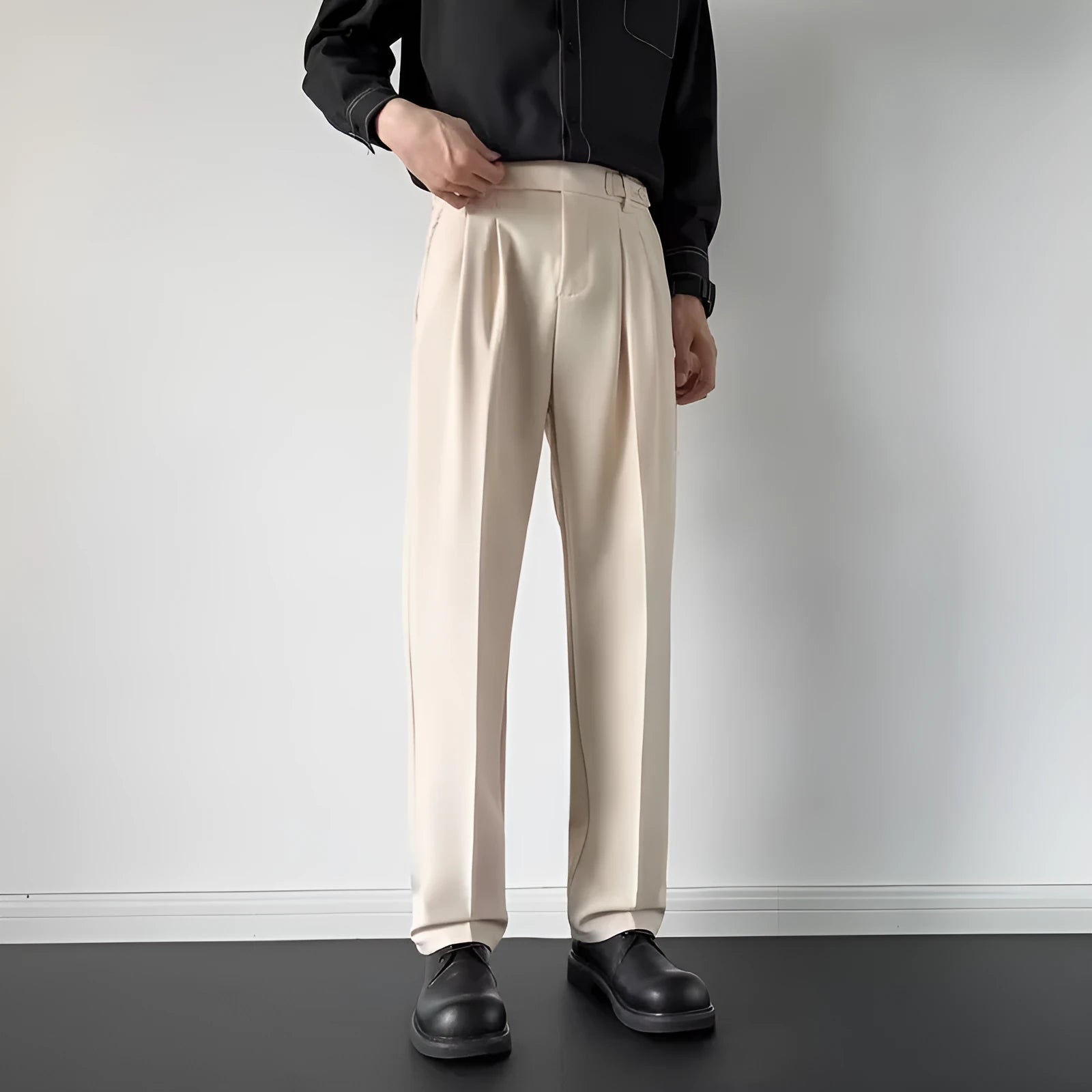 Men's apricot and black straight leg loose fit trousers on a hanger, showing the polyester fabric.