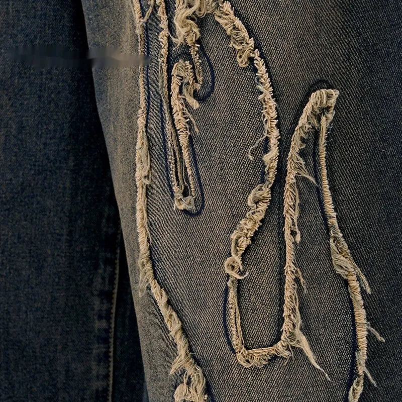 Man wearing black cropped denim shorts with a flame embroidery patch on the leg, street style.