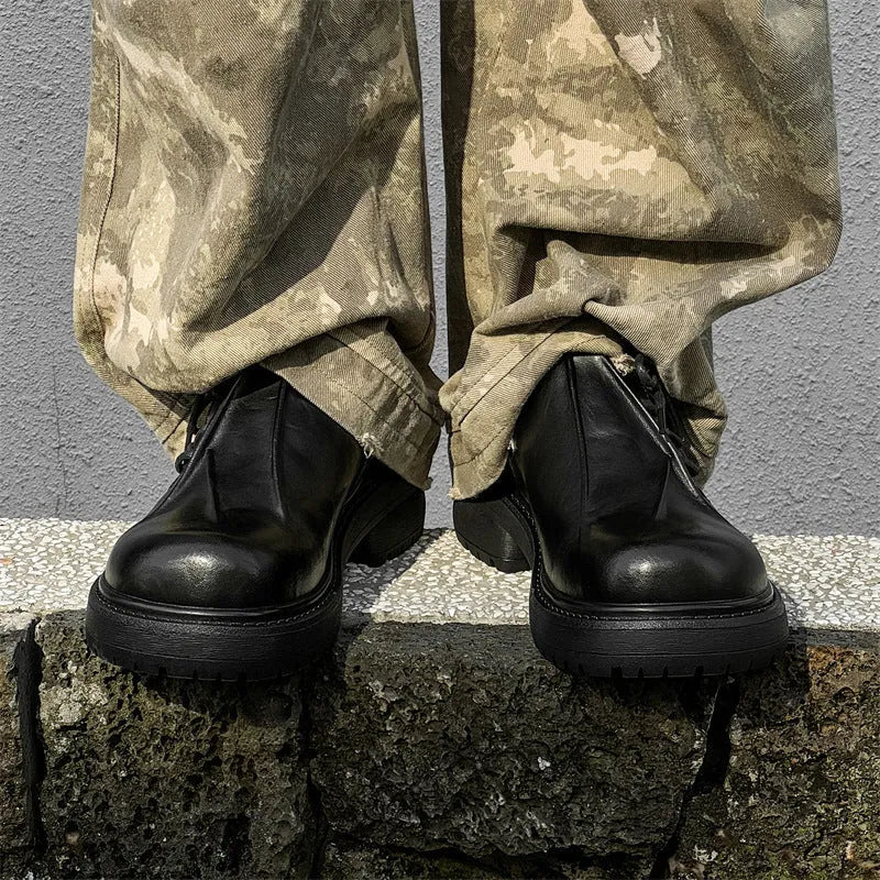Black leather platform shoes with a warped head design and round toe on a rubber sole.