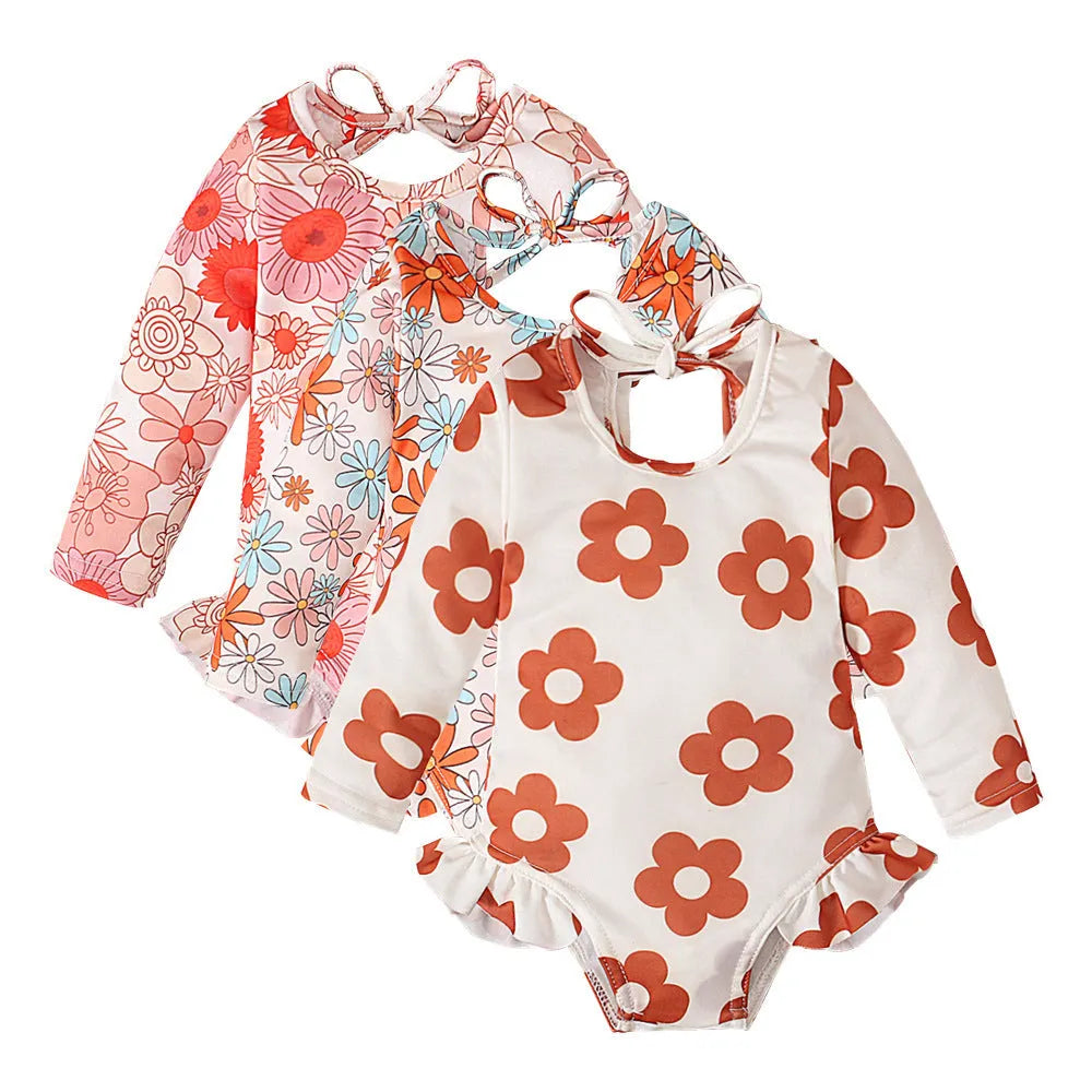 Girl's floral print open back swimsuit in orange red, shown from front and back.