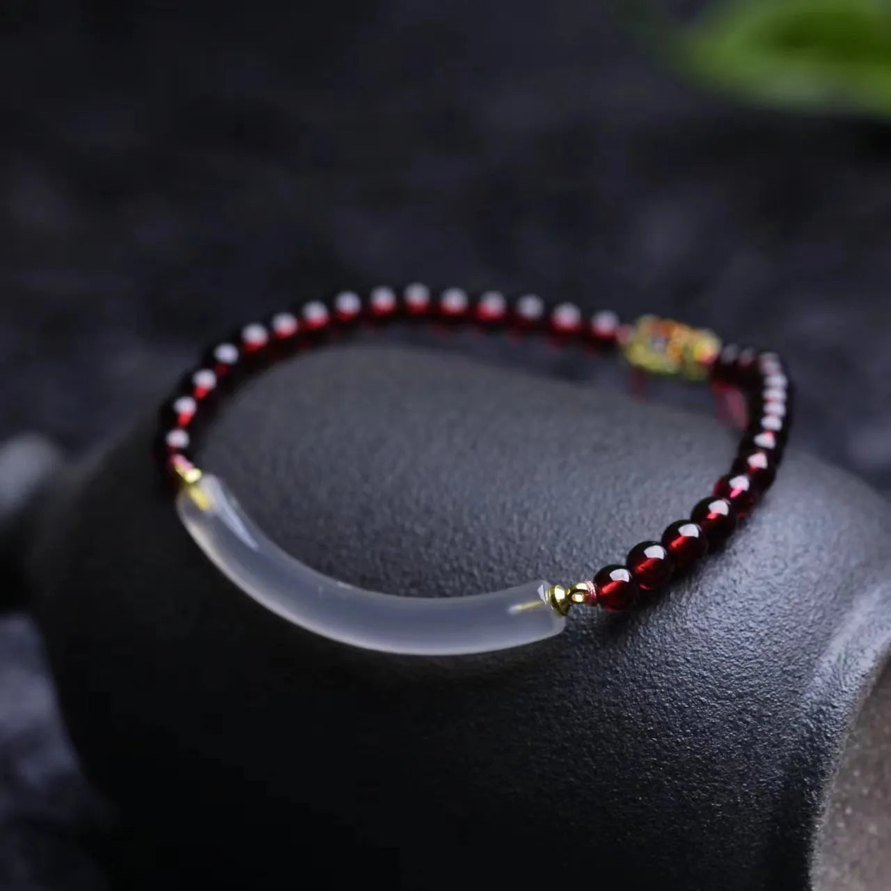 Adjustable red garnet and agate beaded bracelet with pull bead closure on wrist