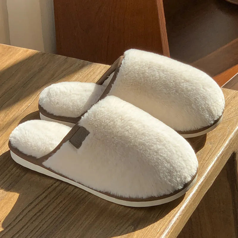 Pair of solid-colour plush winter slippers with a PVC upper and non-slip sole.