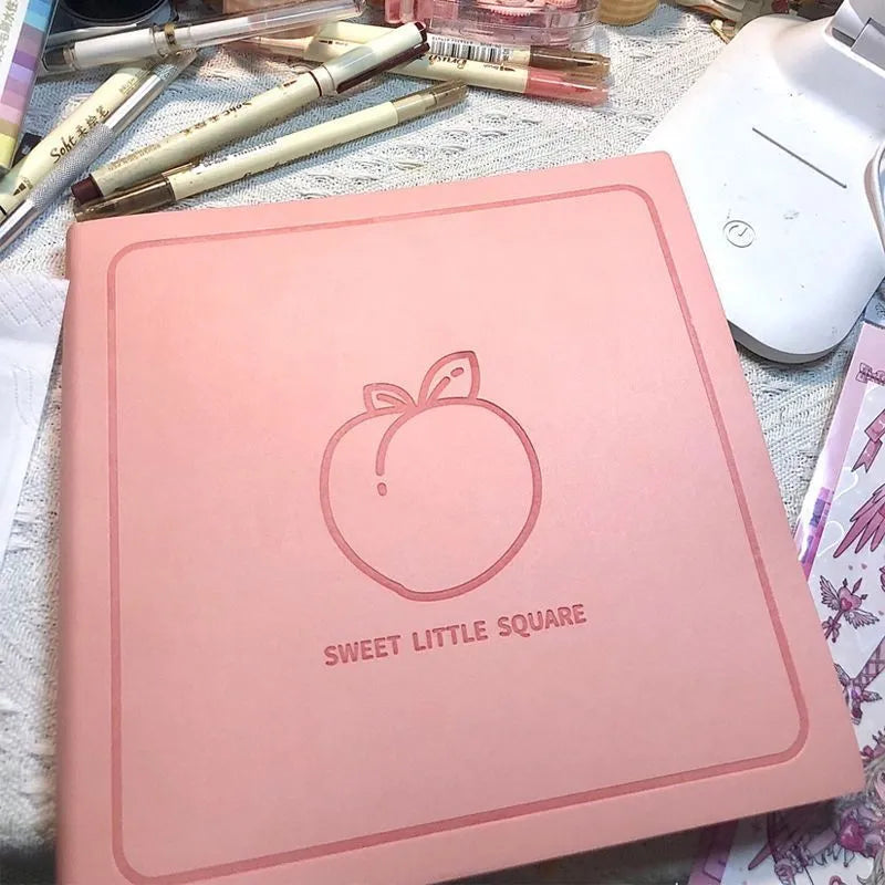 Square faux leather notebook in peach pink, avocado green, or grey green with blank, lined, or grid pages.