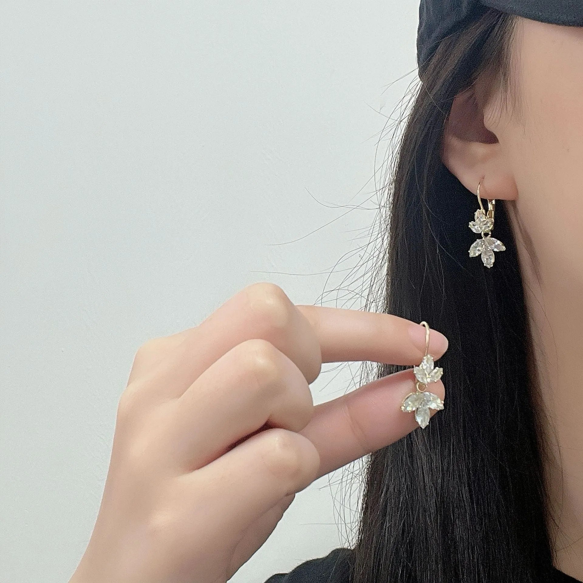 Platinum colour leaf-shaped earrings with zircon inlay creating shiny reflective surfaces