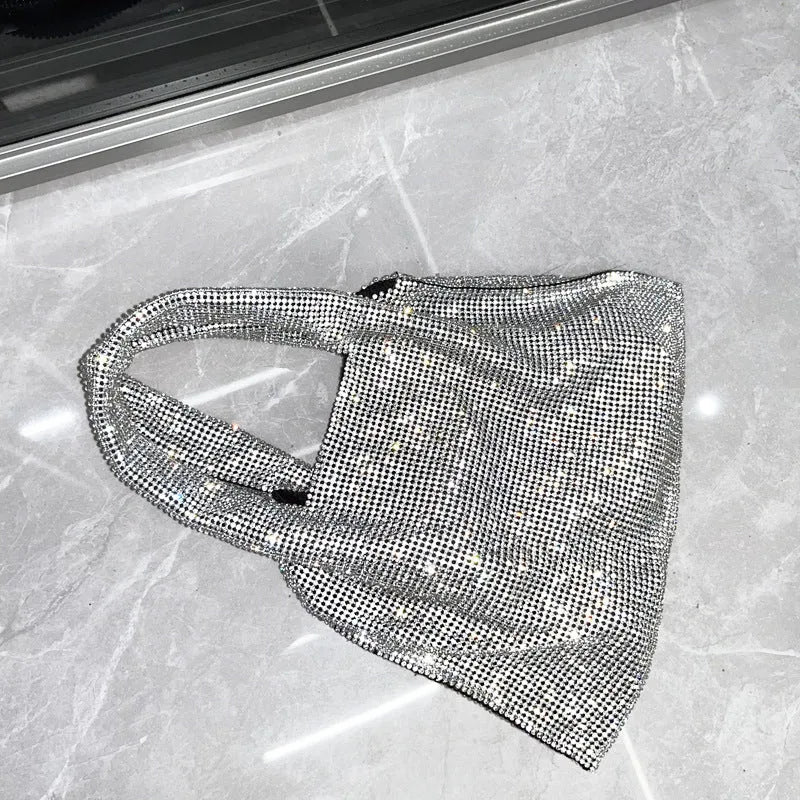 Silver handbag decorated with shiny rhinestones, made from cotton thread with one open pocket.