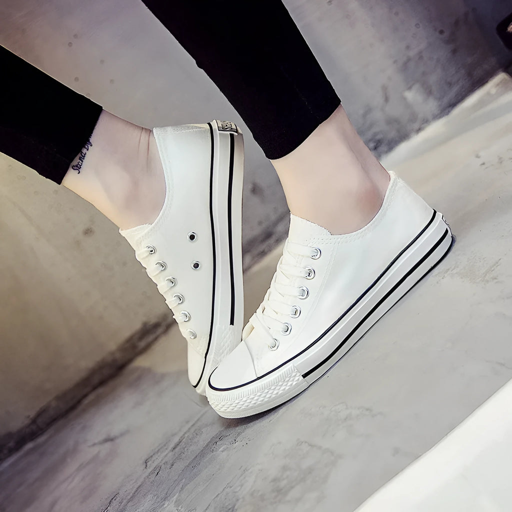 Women's solid colour canvas slip-on sneaker in black on a white background.