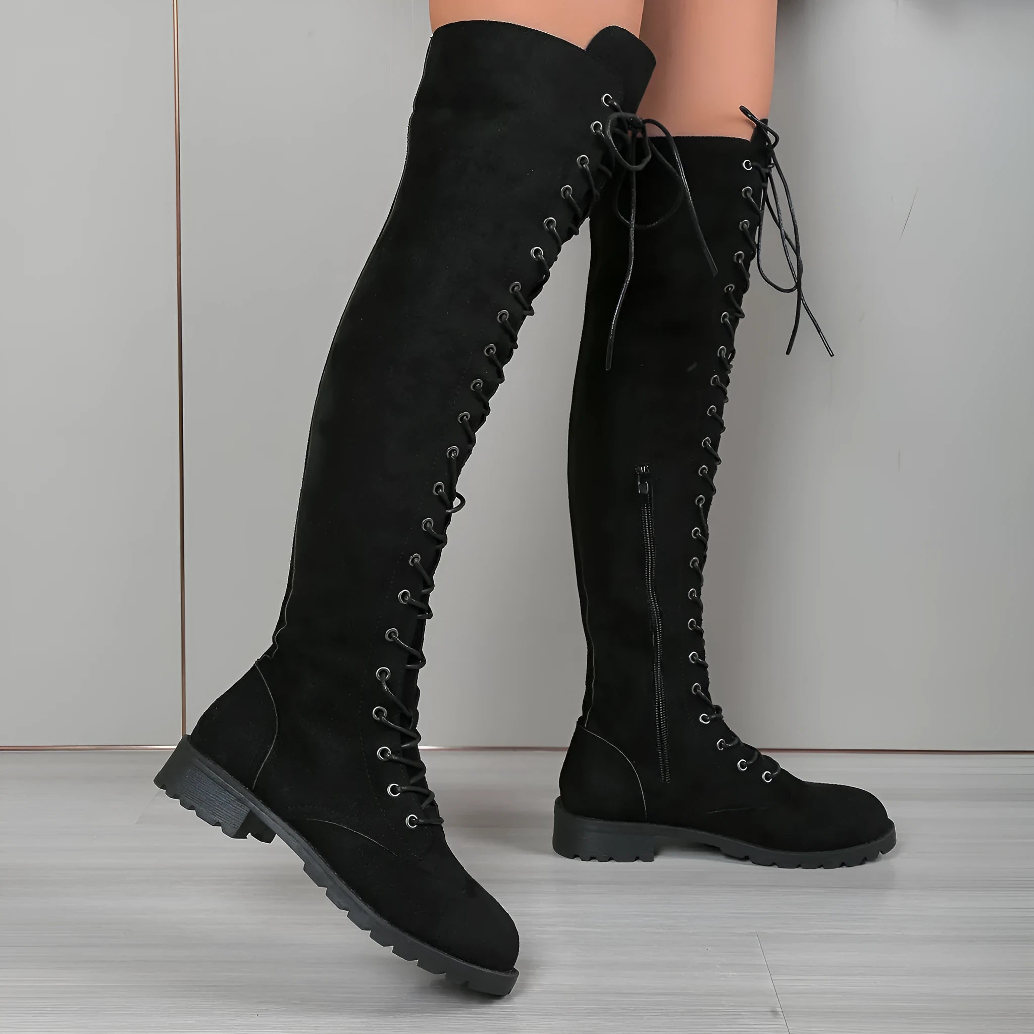 Women's black lace-up over-the-knee boots with decorative stitching and flat rubber soles