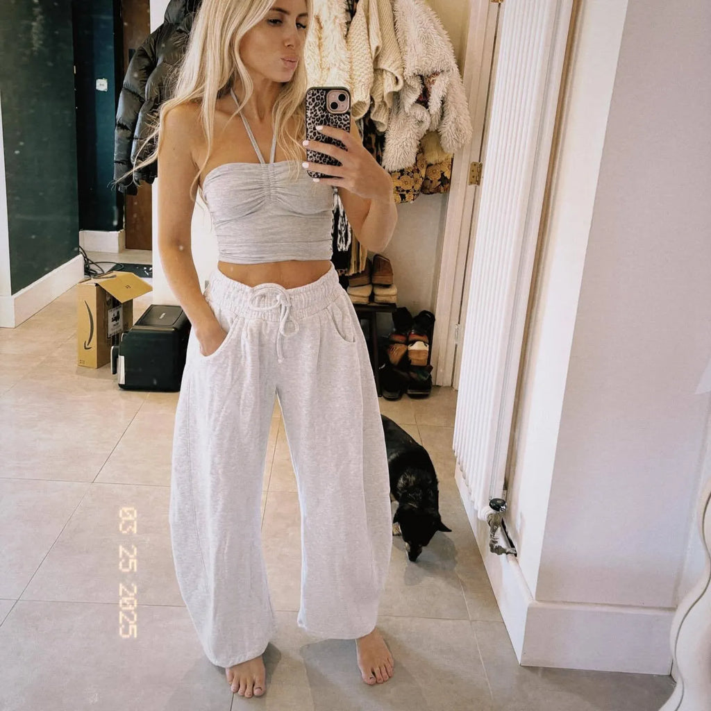 Women's loose cropped sweatpants in apricot colour with drawstring waist and side pockets on a neutral background.