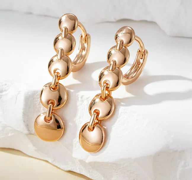Gold-coloured retro woven round copper earrings showing textured circle design.