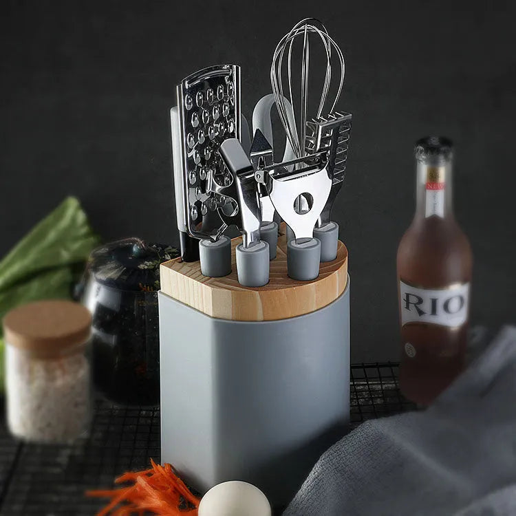 Stainless steel kitchen gadgets set with whisk, peeler, scissors, and fruit knife on grey tray