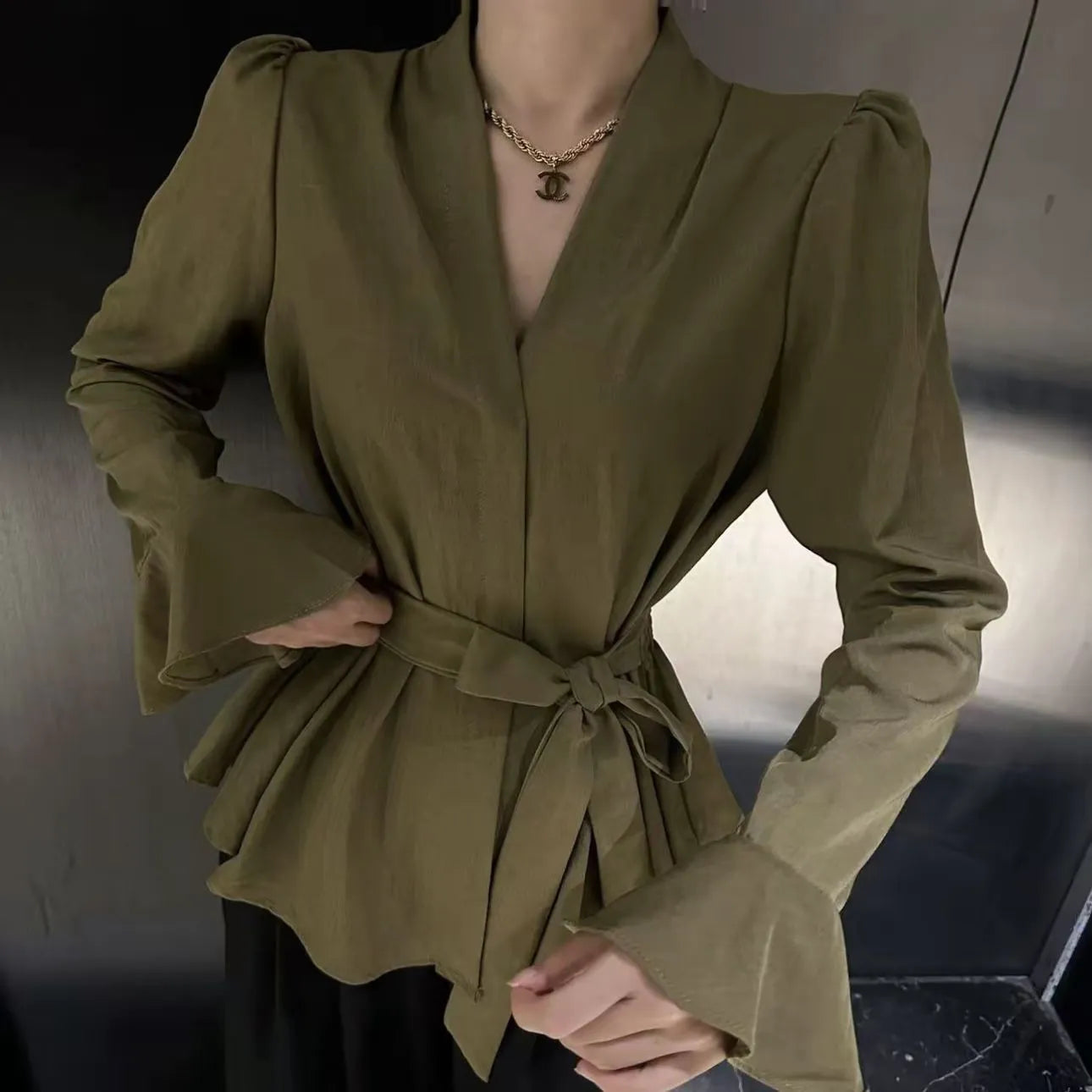 Women's black polyester shirt with a French-style irregular collar and long bell sleeves.