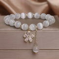 Women's white cat's eye stone bracelet with morganite pendant and flower tassel on safety buckle clasp