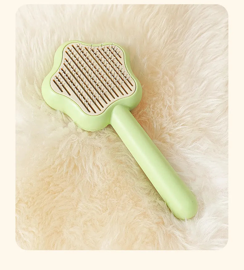 Green self-cleaning cat comb with four stainless steel needles measuring 20cm long