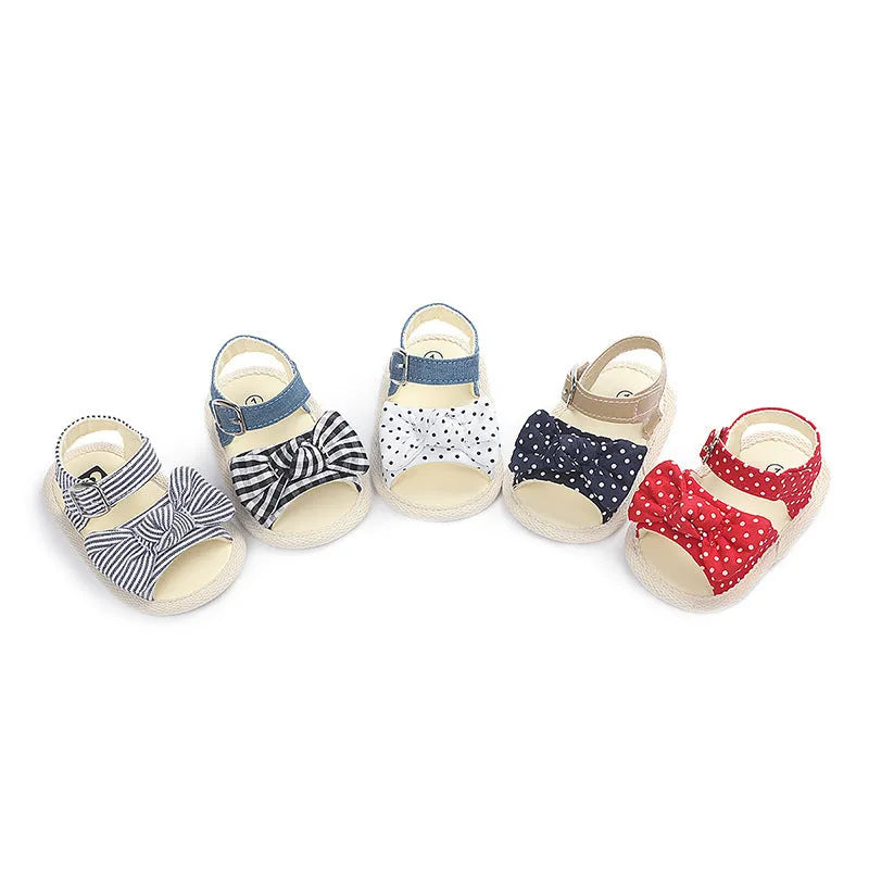 White and black low tube baby shoes with Velcro strap closure for toddlers.