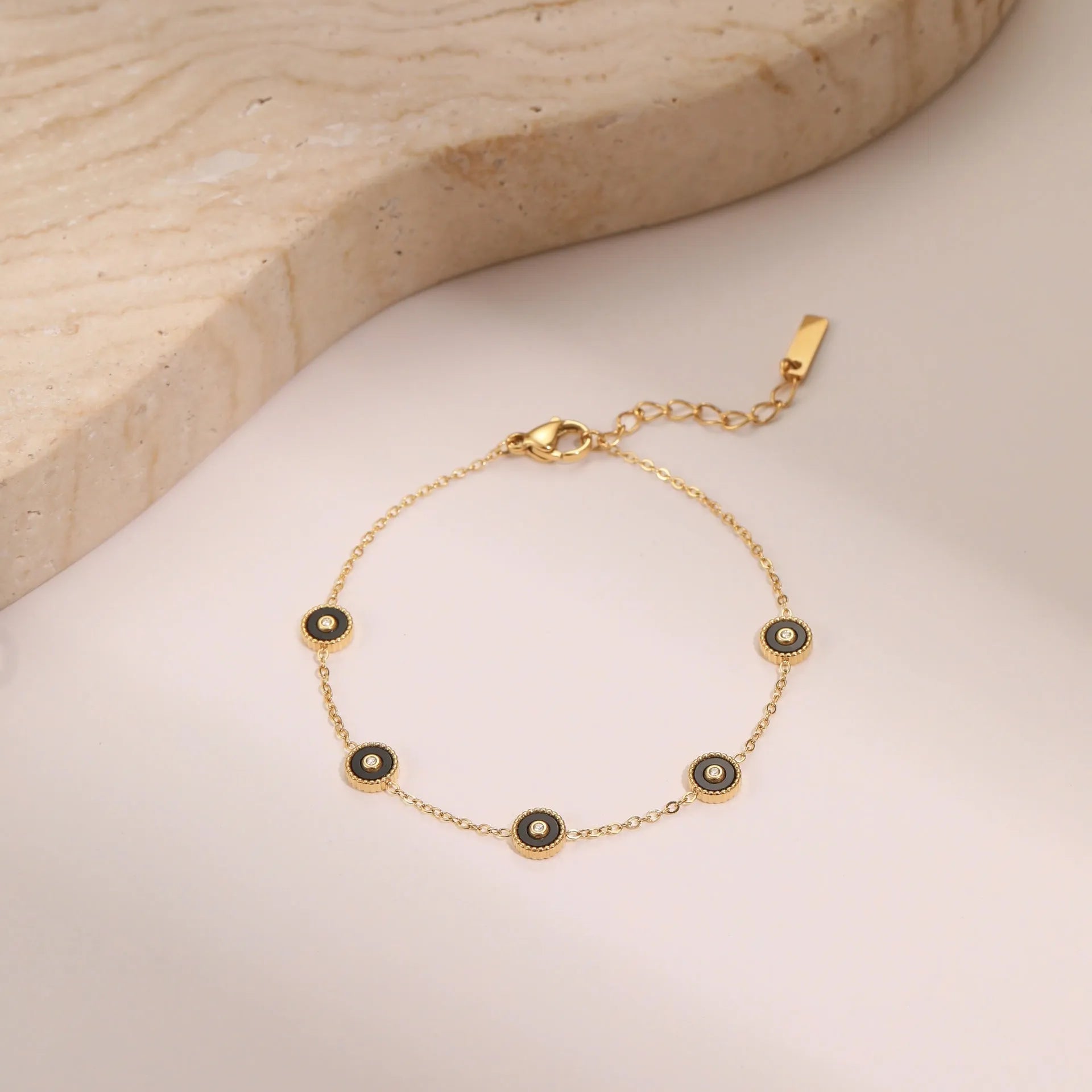 Geometric women's stainless steel bracelet with 18K gold electroplating alongside matching necklace