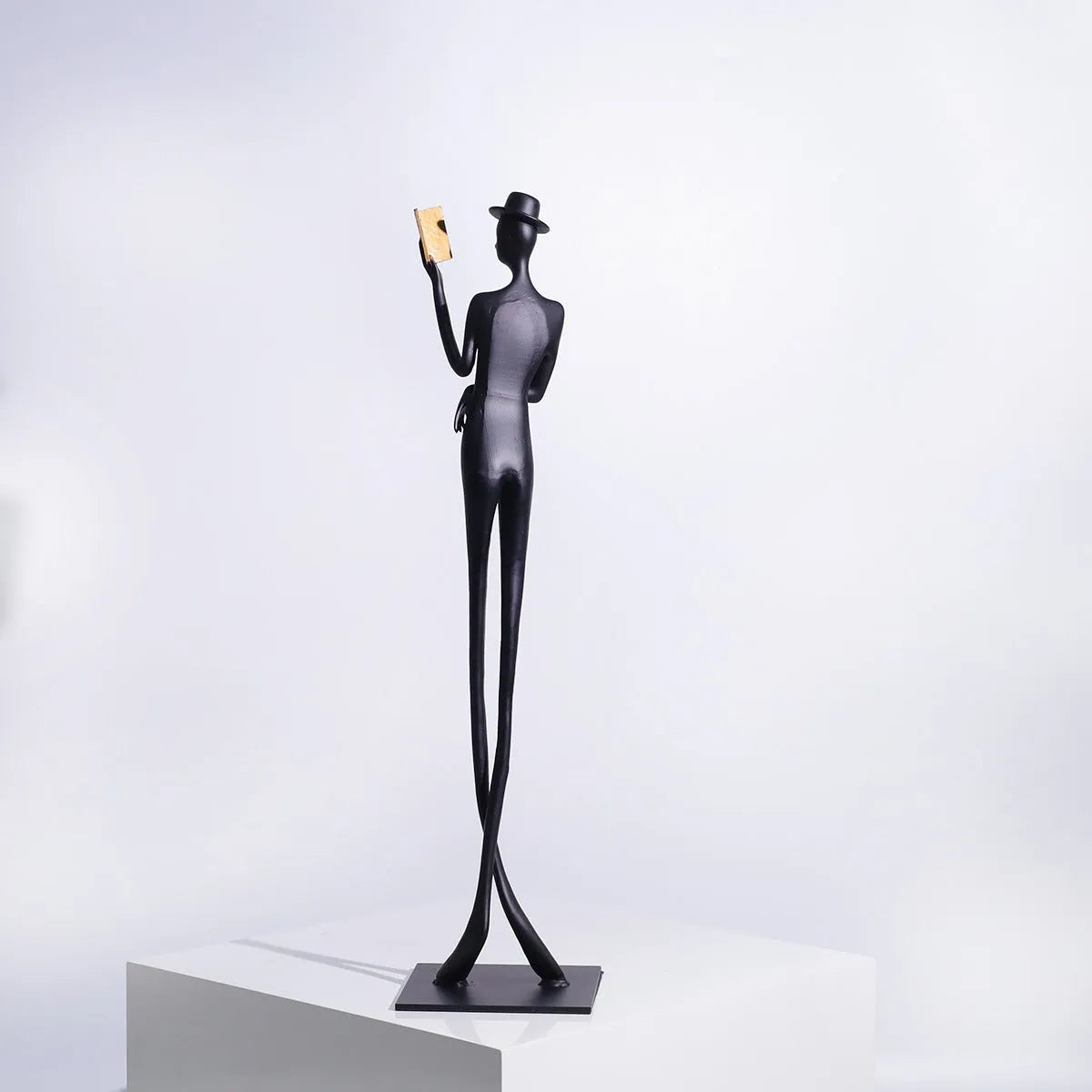 Black cast aluminium desktop sculpture of reading woman measuring 12x12x51cm