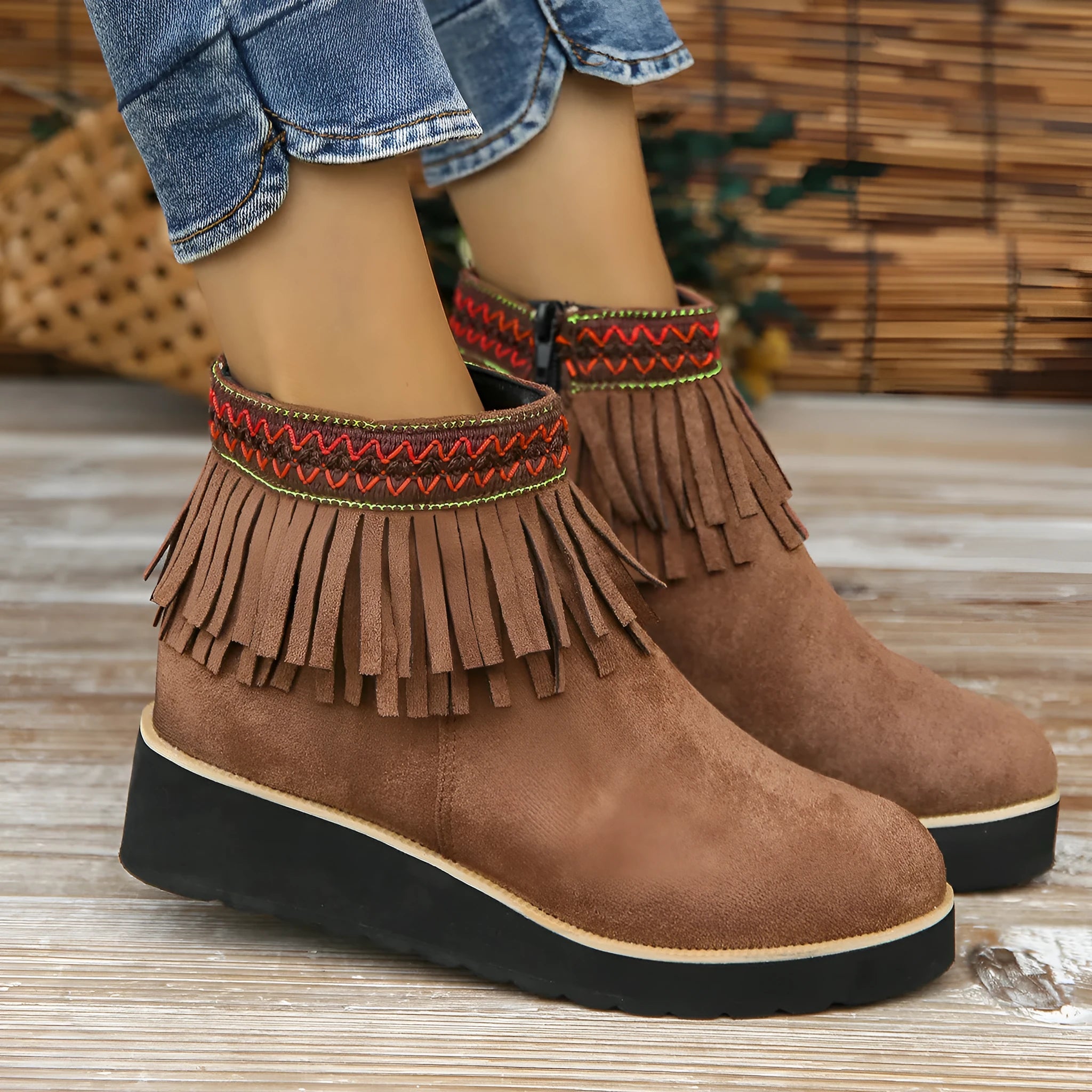 Women's black suede wedge ankle boots with a side zip and tassel detail on a thick rubber sole.