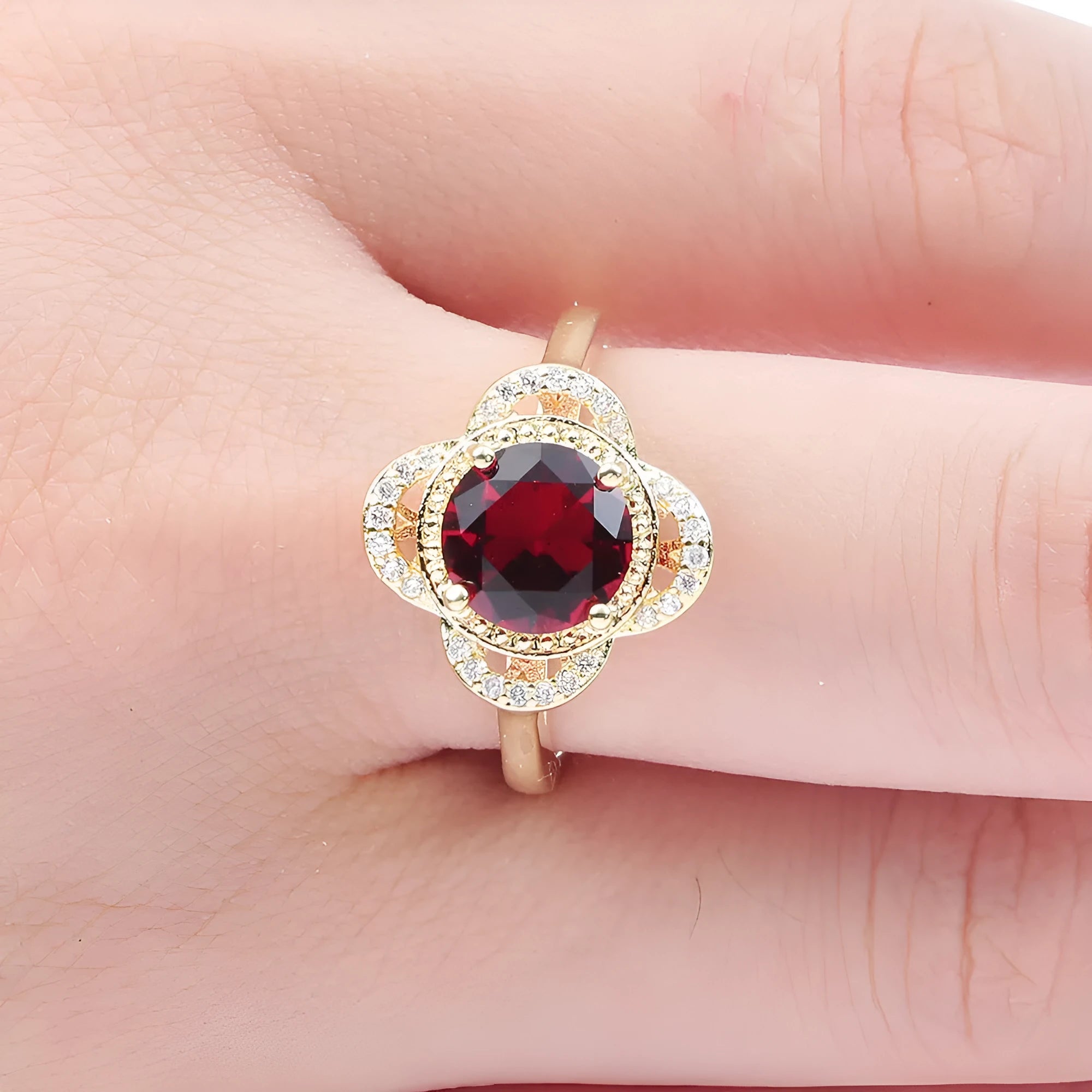 Copper fruit-shaped ring with a central zircon inlay on a model's finger.