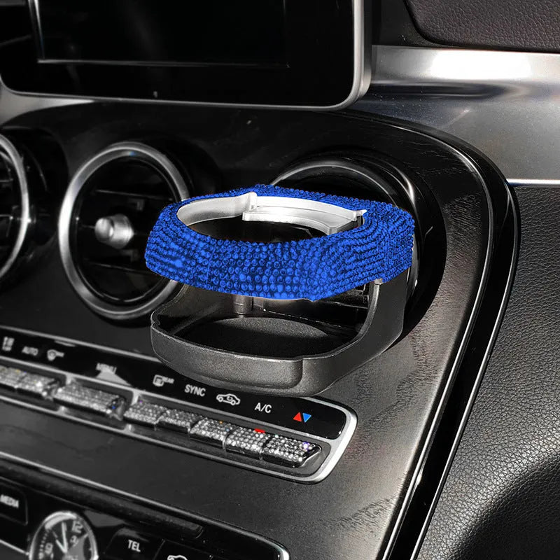 Car interior ashtray bracket with cup holder and rhinestone decoration mounted on air vent.