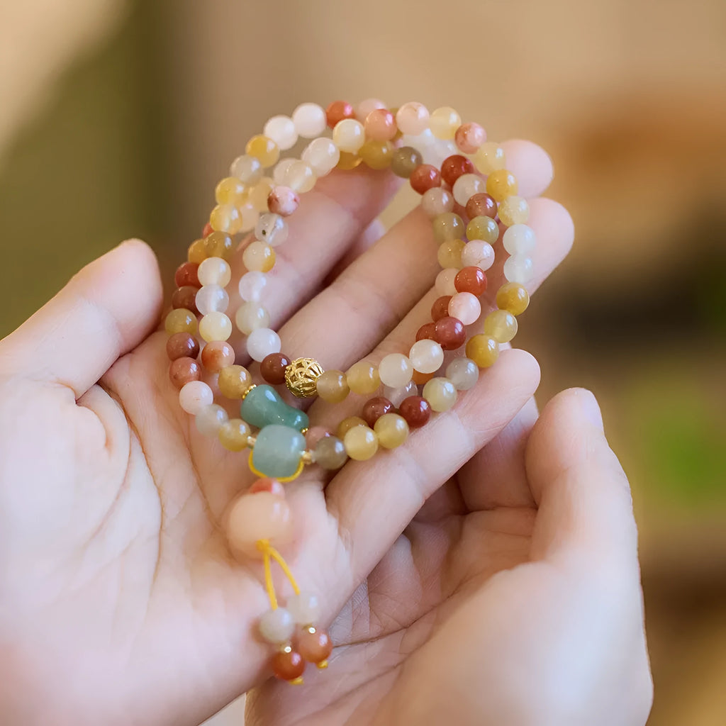 Women's Jinsi Jade bracelet with three-circle pumpkin design and tassels on a wrist