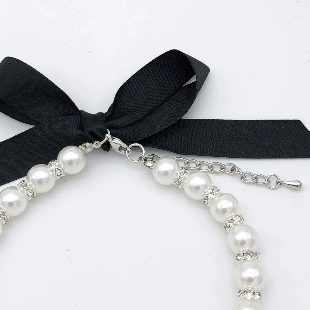 Small dog wearing blue imitation pearl necklace with rhinestones and ribbon bow adjustable collar