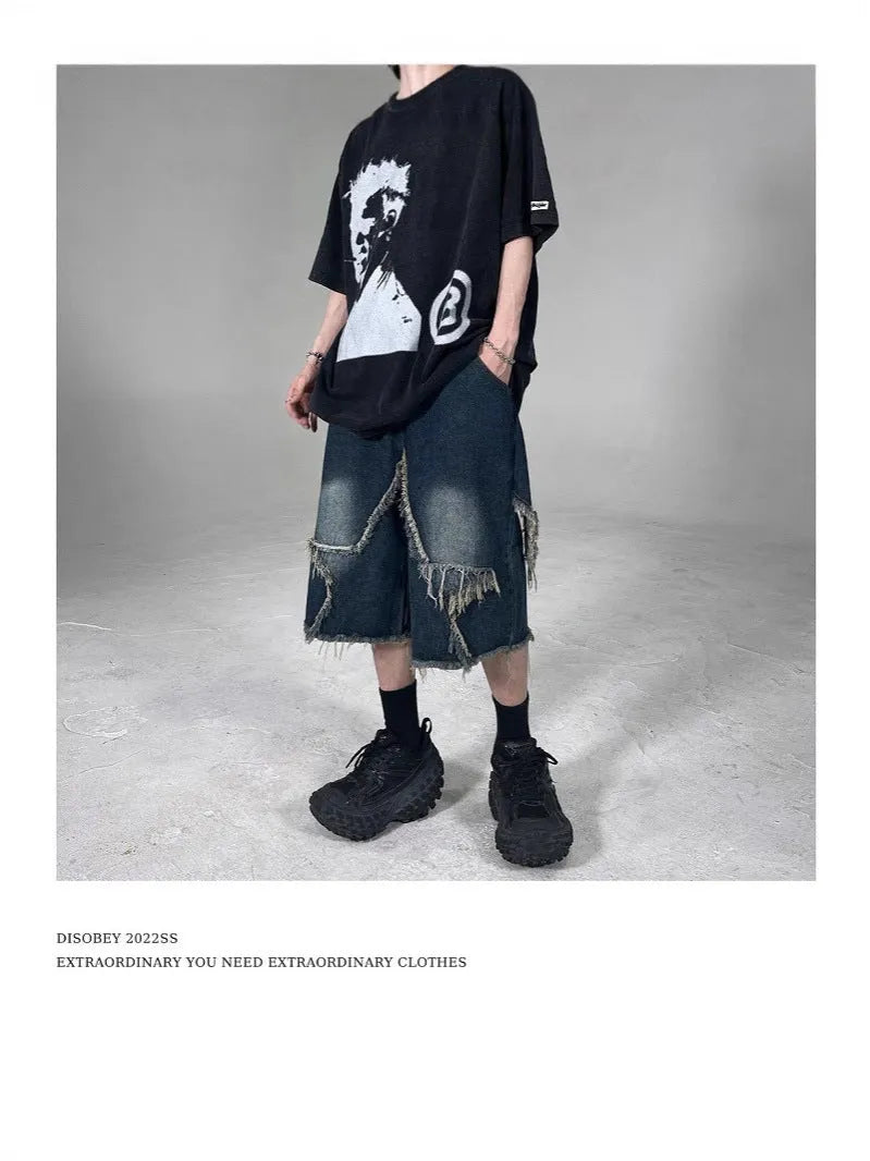 Blue denim shorts with a frayed hem and a large five-pointed star design on the leg, shown on a model.