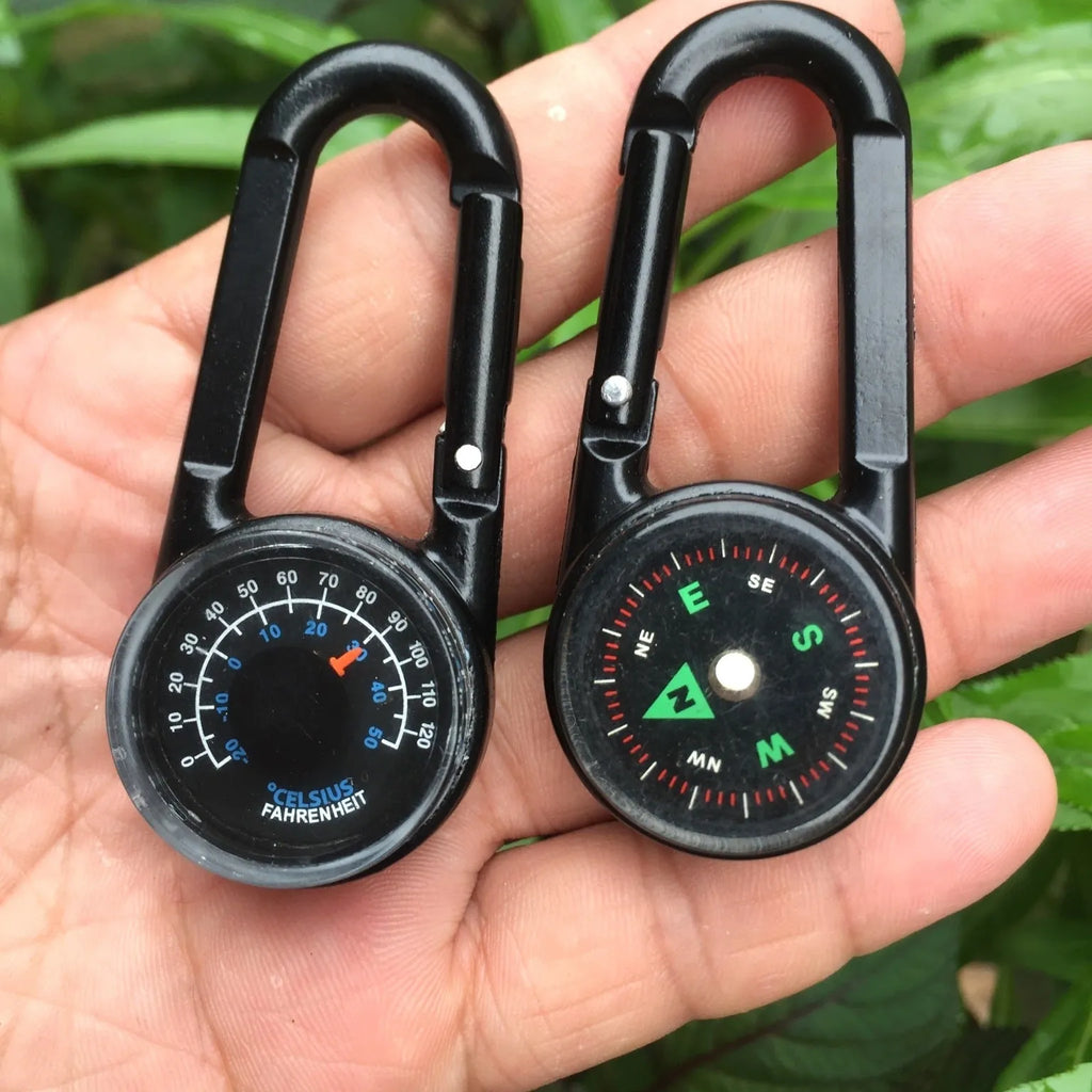 Black zinc alloy camping carabiner with built-in compass and thermometer, showing double-sided button and 65mm size.