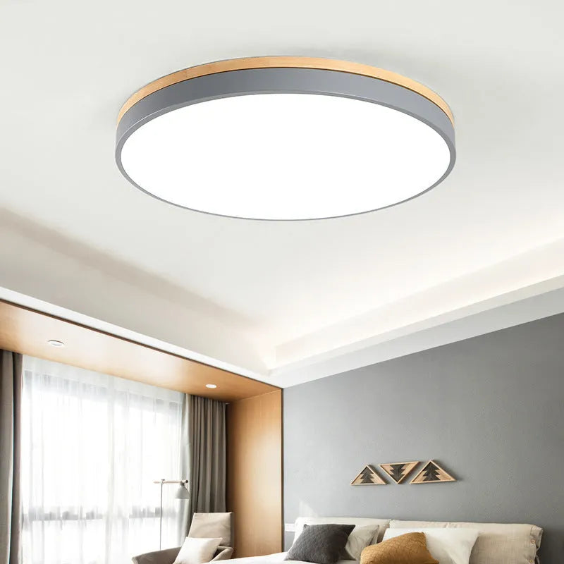 Round Nordic style wooden and iron LED ceiling lamp on a white ceiling.