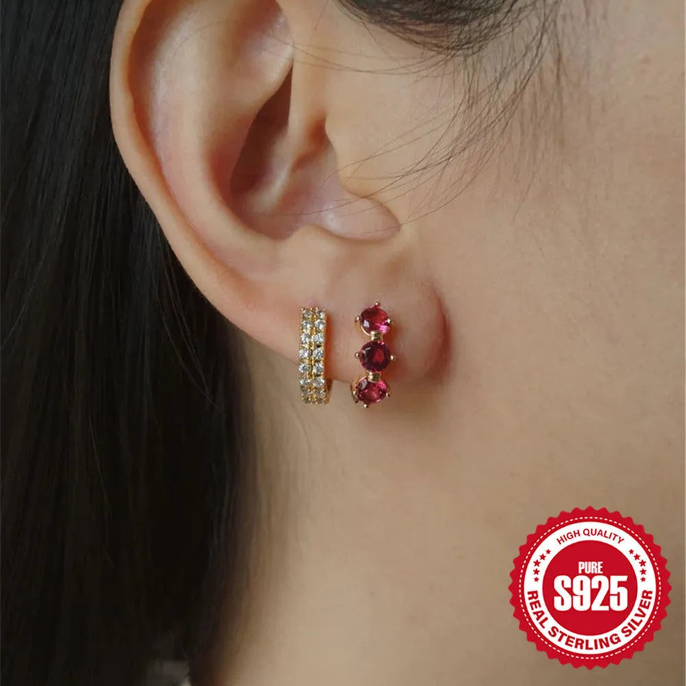 Close-up of sterling silver sunflower earrings with golden zirconia stones on a white background.