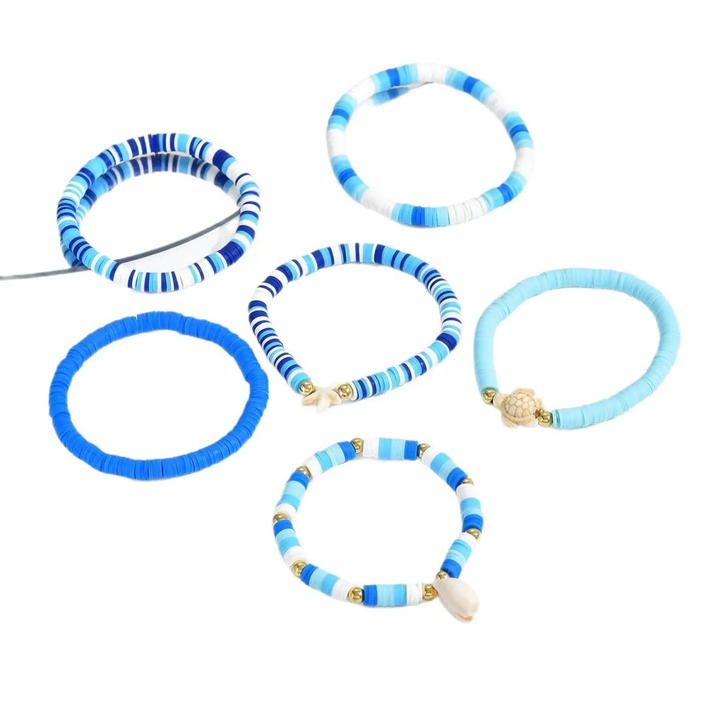 Set of six handmade geometric shell bracelets in Bohemian blue polymer clay.